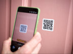 A QR code sticker being scanned by a smart phone